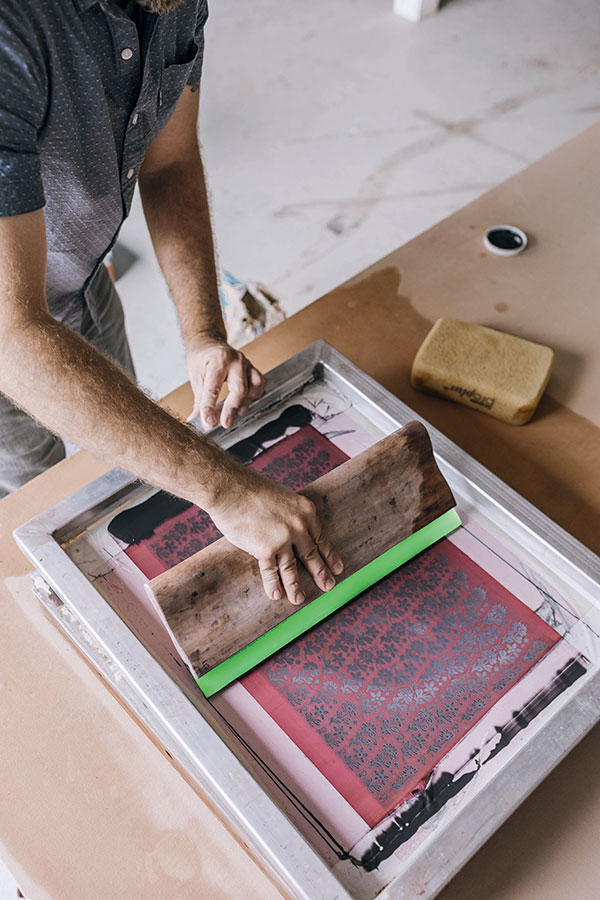 2 Place a long strip of underglaze across the top of the screen, then pull the squeegee down the screen to force a single layer of underglaze through the screen directly onto the plaster slab.