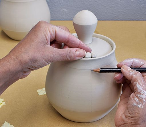 2 Attach a lid stopper on the rim of the pot so that it is in line with the handle.