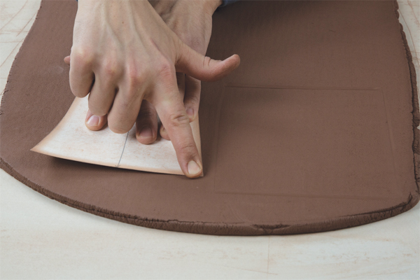 2. Lightly press the template edges into the slab to create impressions indicating where you should cut the slab.