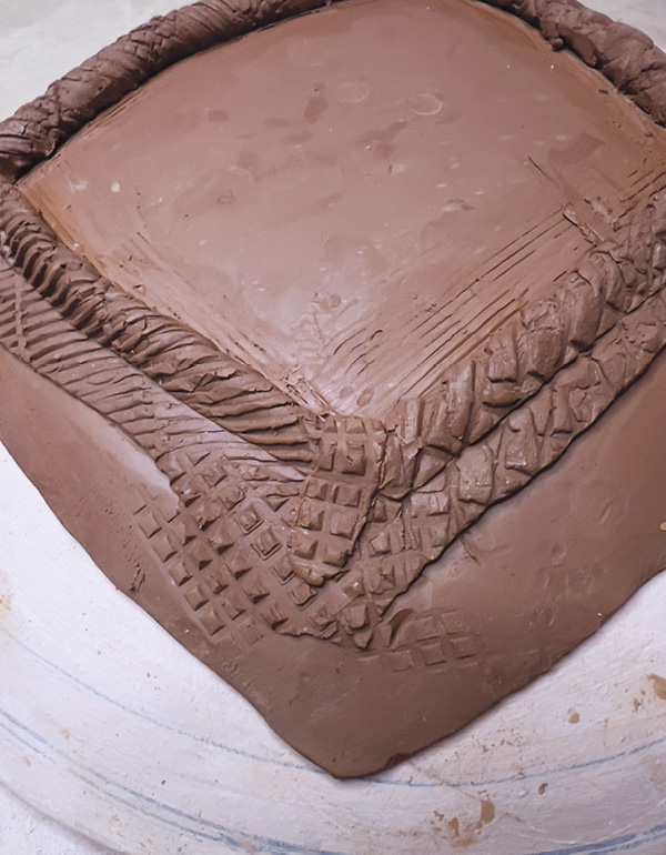 11 Compress the patch of clay using one of your textured rolling tools.