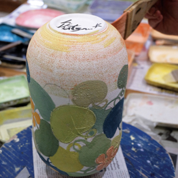 9 Start painting the background. Turn the vase upside down and use a hake brush to apply a thin layer of color.