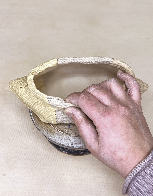 10 Pinch and roll the top edge slightly inward to create a smooth, finished rim.