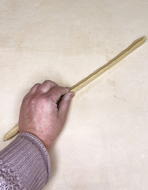 11 Roll a coil from colored clay then shape it into a triangle.