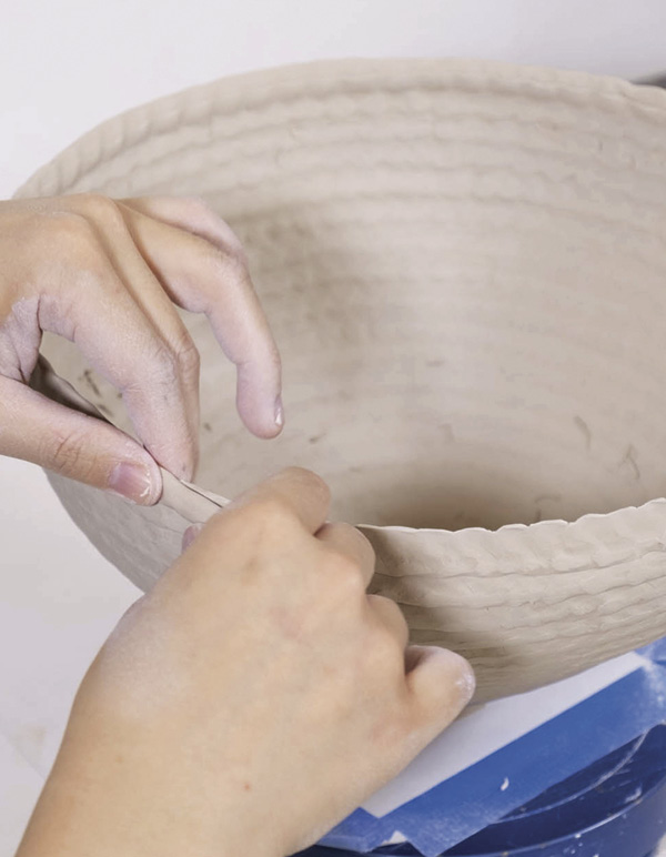 8 Repeat the process: make a coil and attach it halfway up the previous coil.