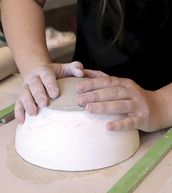 6 Press the center circle onto a hump mold. Smooth and compress it with a rubber rib.