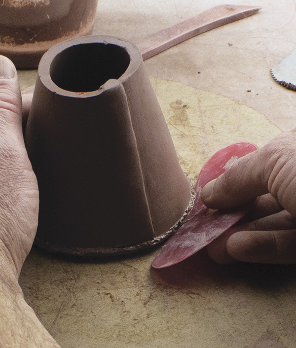 4 Score, slip, and attach the bottoms and tops. Roll the bottom edge of the slab up to attach. Compress the inside seam.