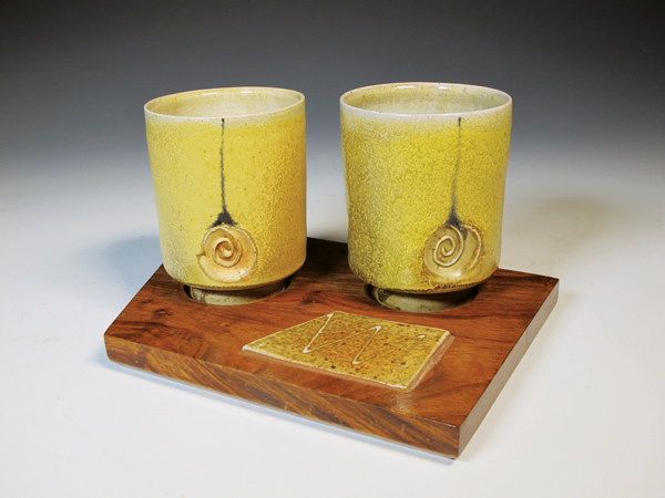Pair of tumblers, 9 in. (23 cm) in width, wheel-thrown white stoneware, off-white terra sigillata, black slip trailing, glaze, fired to cone 11–12 in moderate reduction, recycled African pallet wood with inlaid tile, 2018.