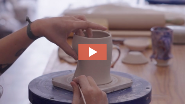 Image of Taylor Sijan refining a dart on a mug form.